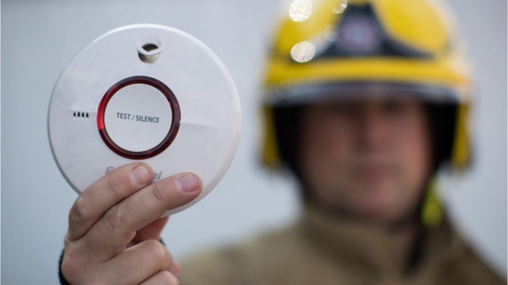 Fireman holding smoke detector